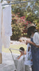 A mother and child hanging up laundry